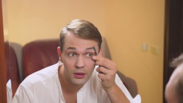 El concepto de metrosexualismo. un hombre guapo delante de un espejo cuida su cara. hace el contorno de la cara, maquillaje todos los días. 4k, cámara lenta — Vídeos de Stock