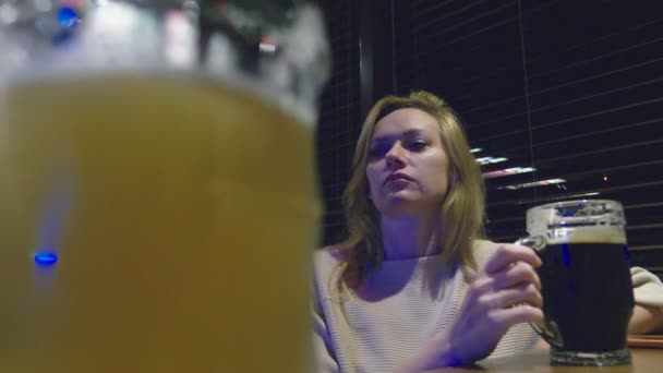 Donna che beve birra fresca scura da un bicchiere in un nightclub — Video Stock