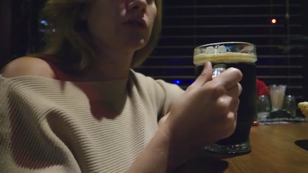 Femme buvant de la bière fraîche noire dans un verre dans une boîte de nuit — Video