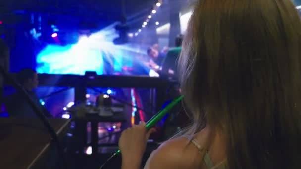 Een meisje een waterpijp rookt en drinkt bier in een nachtclub — Stockvideo