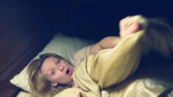 Ужас. В ужасе девушка просыпается ночью в своей постели — стоковое фото