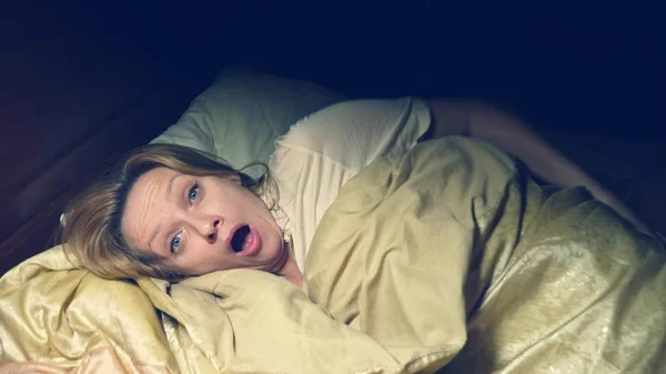 Horror. con horror, la chica se despierta de noche en su cama — Foto de Stock