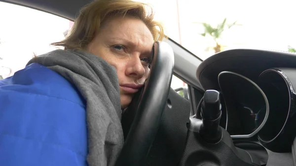 Le conducteur de la femme s'est endormi sur le siège du conducteur sur le bord de la route. Attendre dans la voiture . — Photo