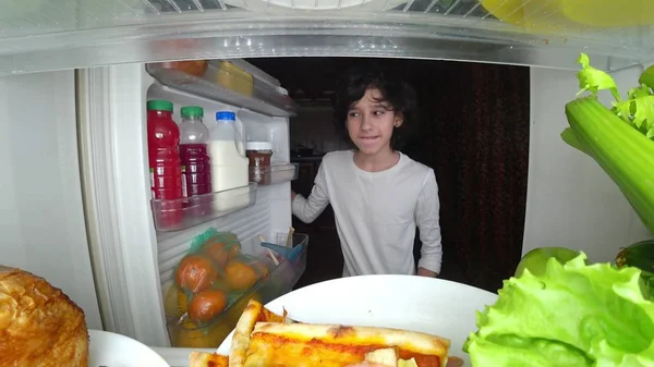 Niño comiendo delante del refrigerador en medio de la noche — Foto de Stock