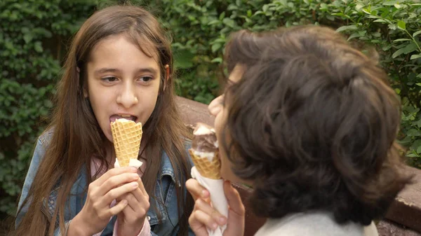 Schattige tieners, jongen en meisje ijs in het park eten en praten — Stockfoto