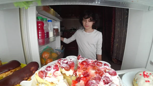 Niño comiendo delante del refrigerador en medio de la noche — Foto de Stock