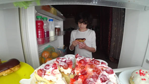 Niño comiendo delante del refrigerador en medio de la noche — Foto de Stock