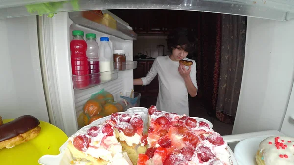Bambino che mangia davanti al frigorifero nel cuore della notte — Foto Stock