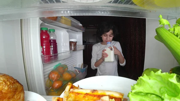 Bambino che mangia davanti al frigorifero nel cuore della notte — Foto Stock