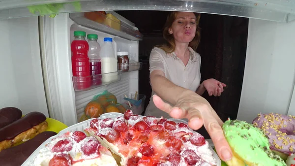 La mujer abre el refrigerador por la noche. hambre nocturna. gula de dieta —  Fotos de Stock