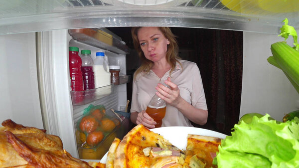 Женщина открывает холодильник по ночам. ночной голод. обжорство
