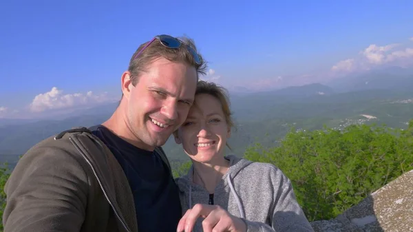 Una coppia, un uomo e una donna fanno un sefi con vista sulle magnifiche montagne — Foto Stock