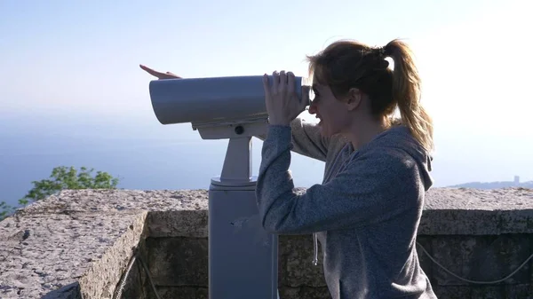 Wanita pirang wisatawan melihat melalui teleskop di atas gunung . — Stok Foto