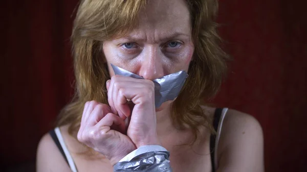 Geweld, misdaad, ontvoering en mensen concept - criminele gelijkmakende vrouw handen met plakband — Stockfoto