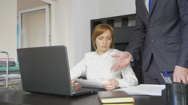 Boze baas met werkneemster in het kantoor. — Stockfoto