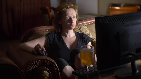 Жінка з комп'ютером, пиво вдома в темряві . — стокове фото