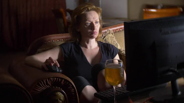 Vrouw met de computer, het drinken van bier thuis in het donker. — Stockfoto