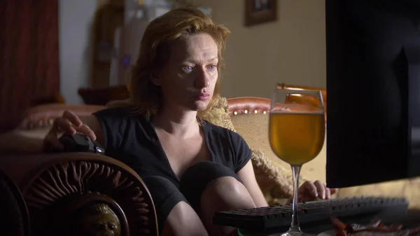 Mujer con computadora, bebiendo cerveza en casa en la oscuridad . — Foto de Stock