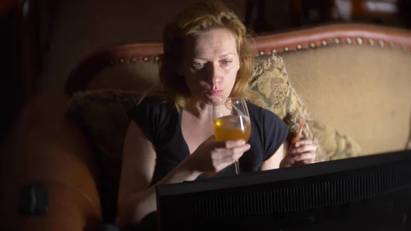 Mujer con computadora, bebiendo cerveza en casa en la oscuridad . — Foto de Stock