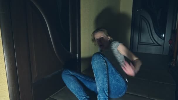恐怖, 一个女孩爬离她的调查员, 下降到地板上的走廊, 她的房子. — 图库视频影像