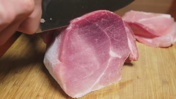 Hombre corta carne cruda congelada con un cuchillo en cámara lenta. 4k primer plano — Vídeo de stock
