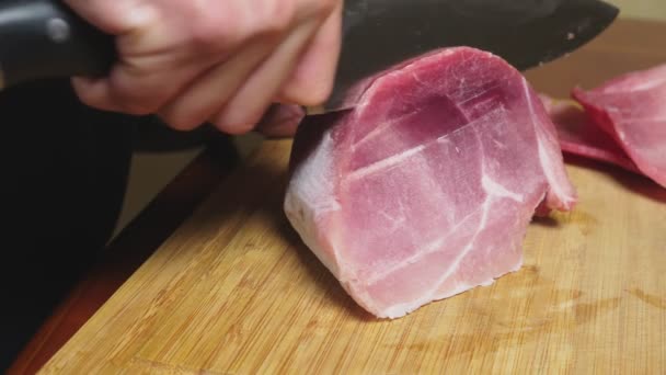 Man klipper rå fryst kött med en kniv i slow motion. 4 k närbild — Stockvideo