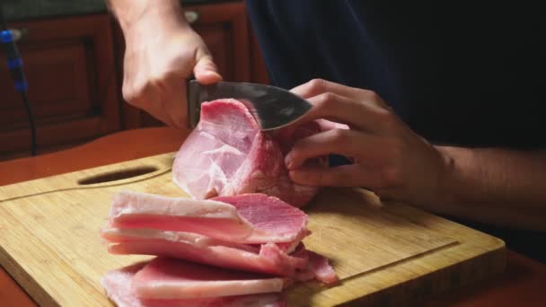 男は、スローモーションでナイフで生冷凍肉をカットします。4 k のクローズ アップ — ストック動画