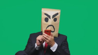 duygu, jest kavramı. saldırgan, sinirli boyalı bir surat ile kafasına bir paketi olan bir adam. cep telefonundan konuşuyor