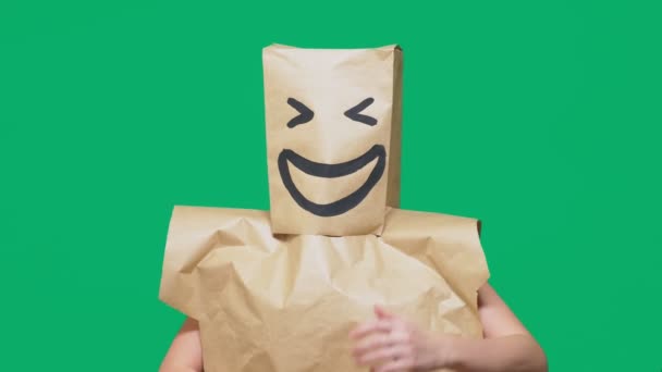 Koncepcja emocje, gesty. człowiek z torby papierowe na głowie, malowane emotikon, uśmiech, radość — Wideo stockowe