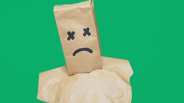 Concept of emotion, gestures. a man with a package on his head, with a painted smiley, exhausted, tired — Stock Video