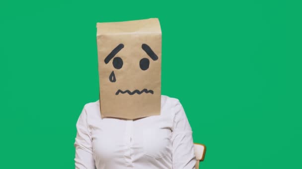 Conceptul de emoție, gesturi. un om cu un pachet pe cap, cu un zâmbet pictat plângând, trist — Videoclip de stoc