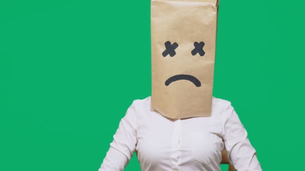 Begreppet känslor, gester. en man med ett paket på huvudet, med en målad smiley, utmattad, trött — Stockvideo