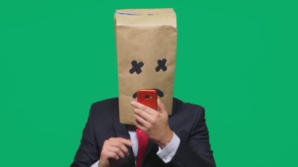 Концепция эмоций, жестов. мужчина с пакетом на голове, с разрисованным лицом, истощенный, уставший, разговаривающий по телефону — стоковое видео