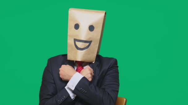 Concepto de emociones, gestos. un hombre con bolsas de papel en la cabeza, con un emoticono pintado, sonrisa, alegría — Vídeos de Stock