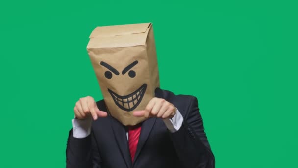 Concept of emotion, gestures. a man with a package on his head, with a painted smiley angry, sly, gloating — Stock Video