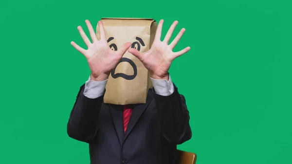 Concepto de emociones, gestos. un hombre con bolsas de papel en la cabeza, con un emoticono pintado, miedo . — Foto de Stock