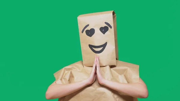 Koncepcja emocje, gesty. człowiek z torby papierowe na głowie, malowane emotikon, uśmiech, radość, miłość oczy. — Zdjęcie stockowe