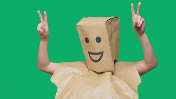 Concepto de emociones, gestos. un hombre con bolsas de papel en la cabeza, con un emoticono pintado, sonrisa, alegría —  Fotos de Stock