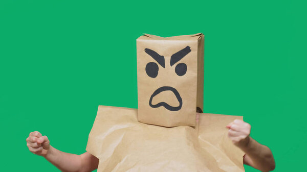 concept of emotion, gestures. a man with a package on his head, with a painted smiley aggressive, angry.