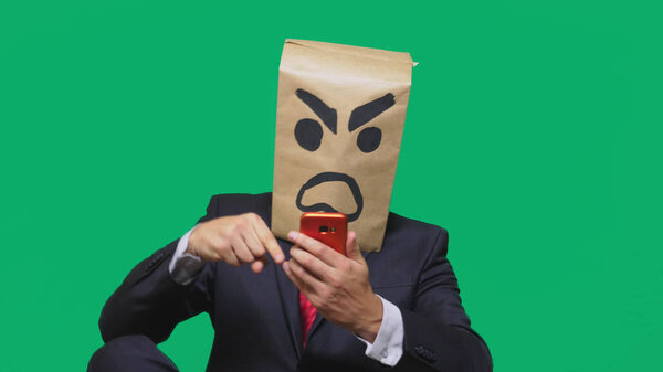 concept of emotion, gestures. a man with a package on his head, with a painted smiley aggressive, angry. talking on a cell phone
