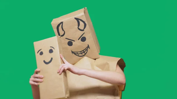 Concept of emotions, gestures. a man with a package on his head, with a painted emoticon devil, crafty, gloating. plays with the child drawn on the box. childs deception, naivety — Stock Photo, Image