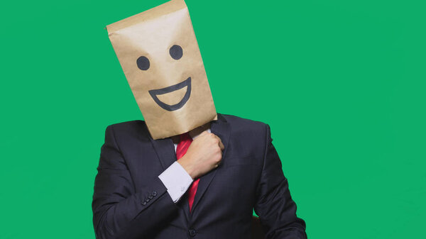 concept of emotions, gestures. a man with paper bags on his head, with a painted emoticon, smile, joy