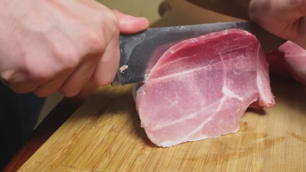 Adam ham dondurulmuş et yavaş çekimde bir bıçakla keser. 4 k yakın çekim — Stok video
