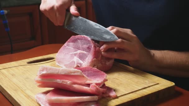 Mann schneidet rohes Tiefkühlfleisch mit Messer in Zeitlupe. 4k Nahaufnahme — Stockvideo