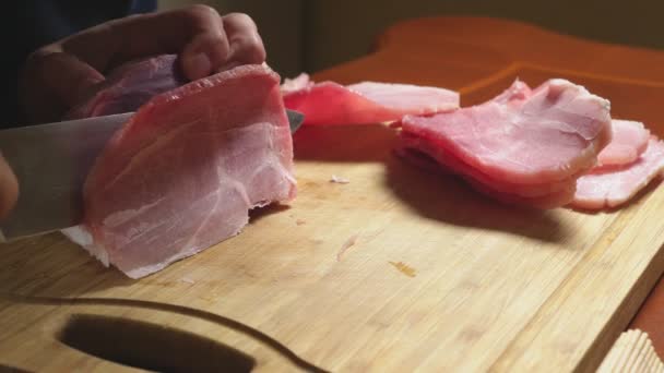 Homme coupe la viande crue congelée avec un couteau au ralenti. Gros plan 4k — Video