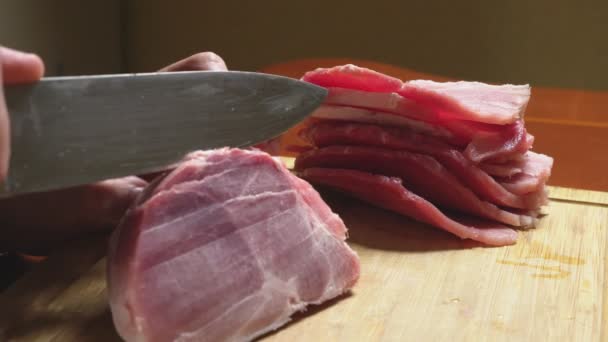 Homme coupe la viande crue congelée avec un couteau au ralenti. Gros plan 4k — Video