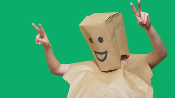 Concept d'émotions, de gestes. un homme avec des sacs en papier sur la tête, avec un émoticône peint, sourire, joie — Video