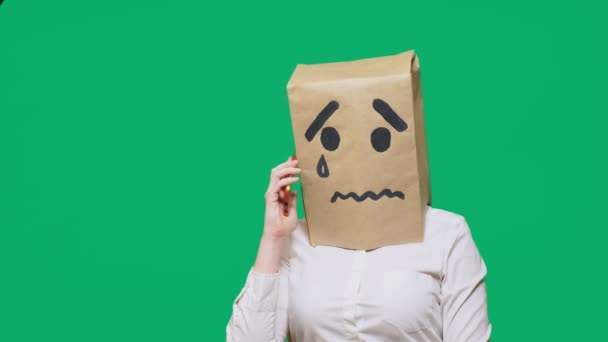 Conceptul de emoție, gesturi. un om cu un pachet pe cap, cu un zâmbet pictat plângând, trist, vorbind la telefon — Videoclip de stoc