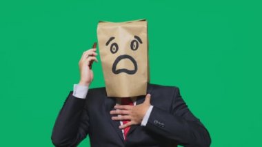 duygular, jest kavramı. boyalı bir ifade ile kafasına kağıt poşet olan bir adam korku. cep telefonundan konuşuyor