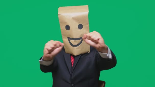 Konzept der Emotionen, Gesten. ein Mann mit Papiertüten auf dem Kopf, mit einem aufgemalten Emoticon, Lächeln, Freude — Stockvideo